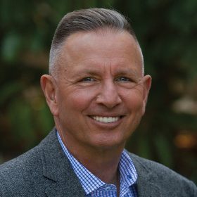 A man with a gray jacket and blue shirt